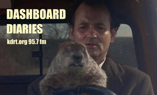 Still shot from the Film Groundhog Day with Bill Murray at the wheel of a pickup while holding Punxatawney Phil