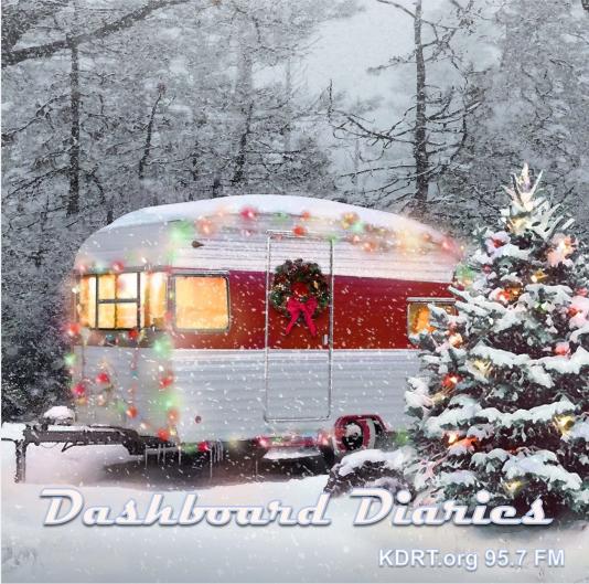 Vintage travel trailer in the snow, decorated for Christmas