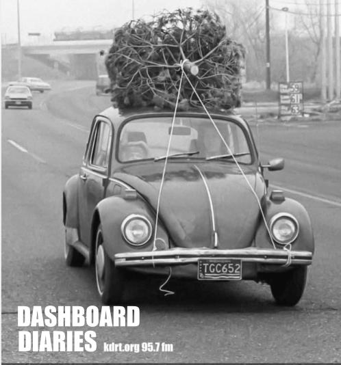 Black and white photo of a vintage VW with a christmas tree on its roof