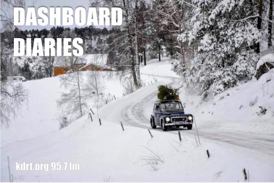 Vintage Volvo driving in snowy country with a tree on the roof