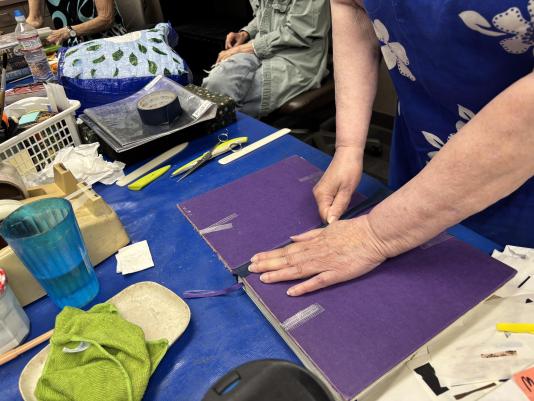 Repairing a book at the Davis Book Menders, July 8, 2025