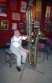 Bandleader Harry Gold playing a contrabass saxophone.