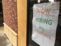 "Now hiring, all positions" sign in a Davis restaurant window